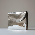 Jacquemus La Pochette Rond Carré clutch bag in silver with a metallic finish.